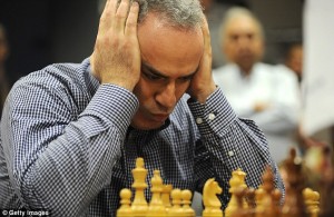 Headache: Former World Chess Champion Garry Kasparov looks over the pieces as he plays a game of chess against South African champion Marcil Roberts last week 