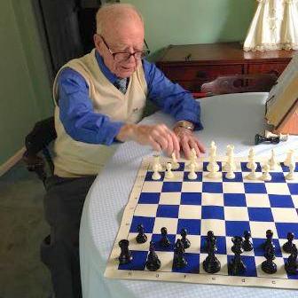 Frank Maguire, 90, plays a game of chess in his west Dearborn home. The nonagenarian taught his son, Mike, to play 50 years ago, and Mike in turn has taught scores of students the game as a chess coach in Indiana. Elizabeth Barbieri -- For The Press & Guide